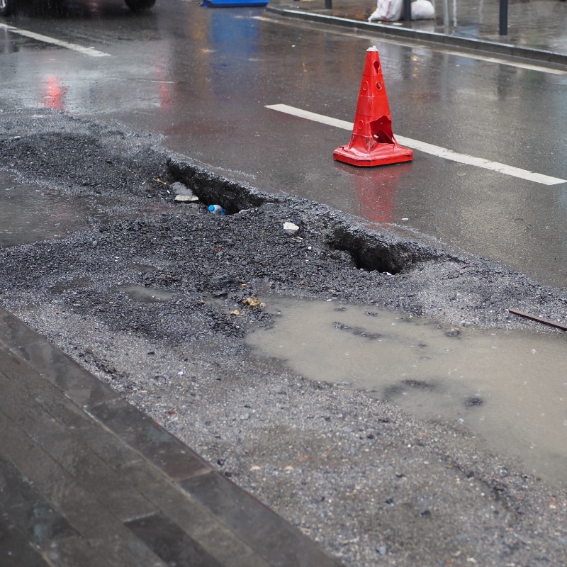 Big pot hole filled with water at street